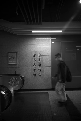 一个男子走进带有墙上的门的电梯