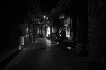 夜晚的黑暗小巷 人们沿着街道走 一个男人也沿着街道走。