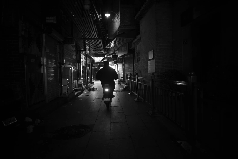 夜晚的黑暗小巷 一个人在街上走。