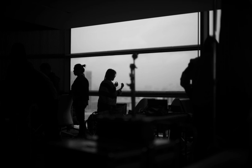 一批人在一间靠近窗户的房间里站着