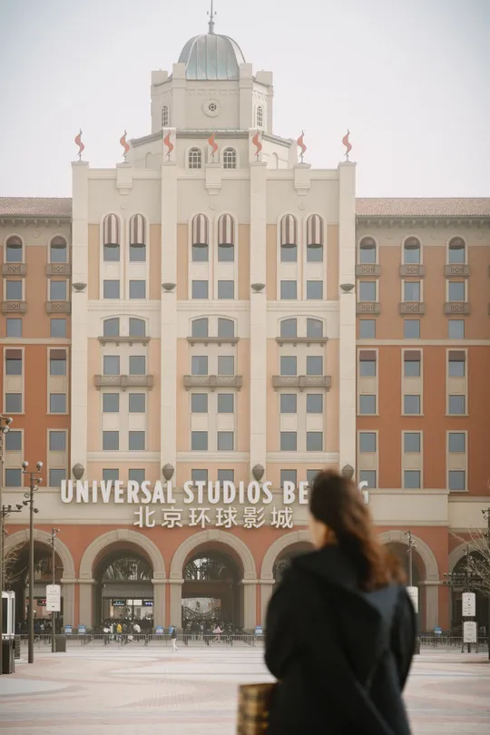 一位妇女站在一栋大楼前面