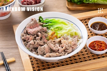 一张木桌 上面有筷子、一份肉类和蔬菜盘以及一份酱汁。