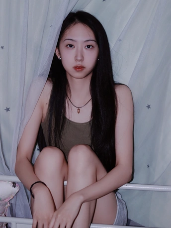 一个年轻女子坐在黑白相间的床上