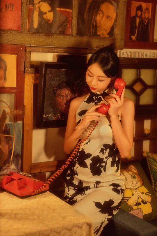 一个穿着连衣裙拿着红色电话的女人坐在房间里