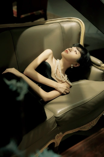 坐在椅子上的一个穿着黑色连衣裙的年轻女人