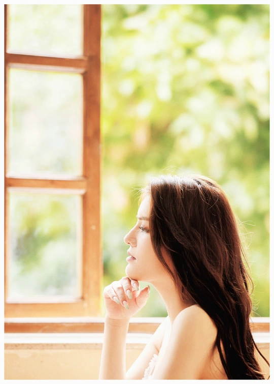 一个坐在窗边向外看的年轻女子