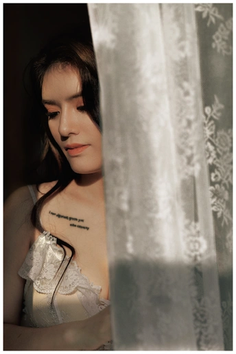 一个穿着白色连衣裙的年轻女子向窗外望去