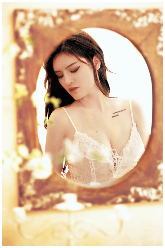 一位穿着白色连衣裙的美丽年轻女士看着镜子里的自己