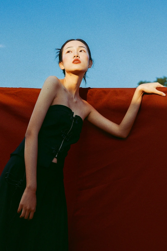一位穿着黑色连衣裙的年轻女子伸出手
