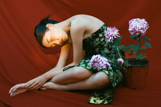 一位穿着红裙子的年轻女子手持一束花