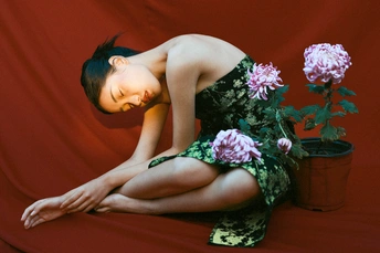 一位穿着红裙子的年轻女子手持一束花