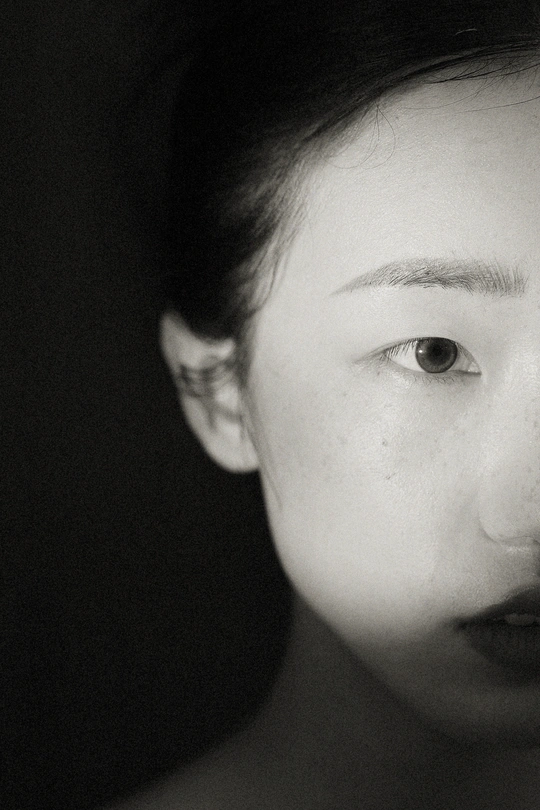 一张黑白照片 一位年轻女子穿着领带 正对着相机。