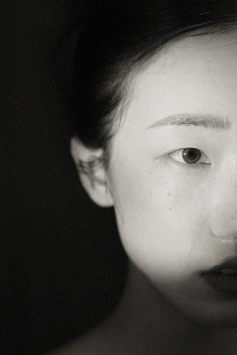 一张黑白照片 一位年轻女子穿着领带 正对着相机。