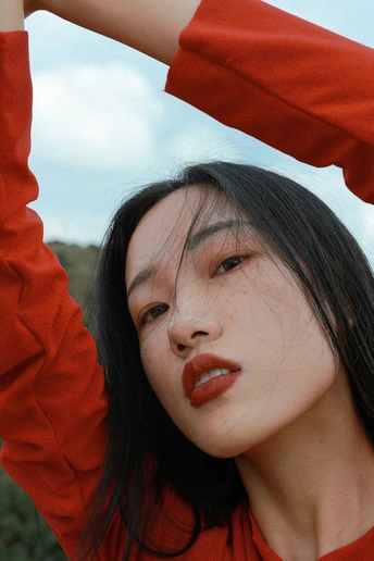 一位年轻女子穿着红衬衫 双手举过头顶