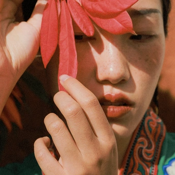 一位戴红头箍的年轻女子用红丝带系在眼睛周围 头戴红花。