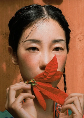 一位年轻女子手里拿着一朵红花 举到她面前