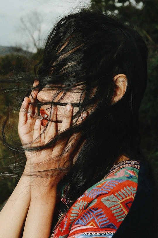 一个长发女子用双手捂住眼睛 头发遮住脸