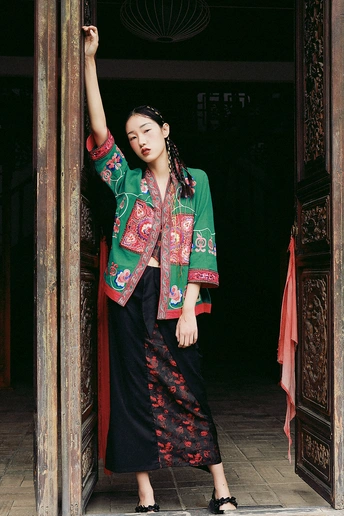 一位身着中国传统服装的年轻女子在寺庙的木门前摆姿势