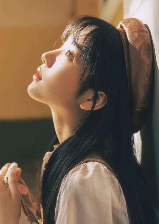 一位年轻女子在窗前梳理头发