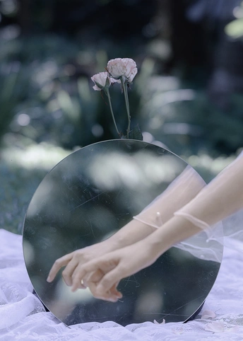 一个人拿着花碰触镜子