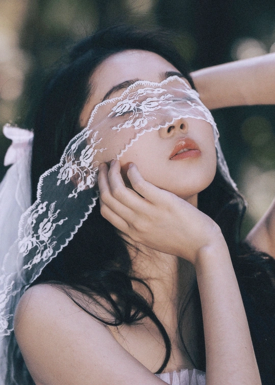 一个戴白色面纱的年轻女子用蕾丝遮住脸