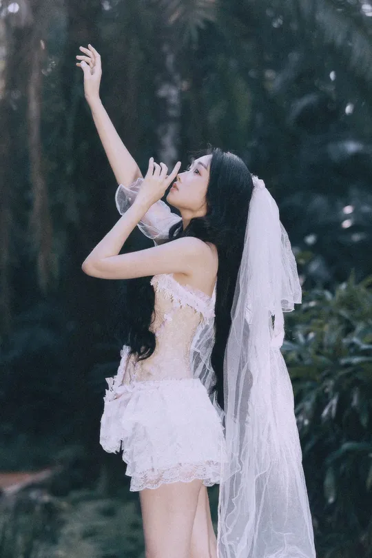 一位穿着白色长裙和面纱的女子在森林中