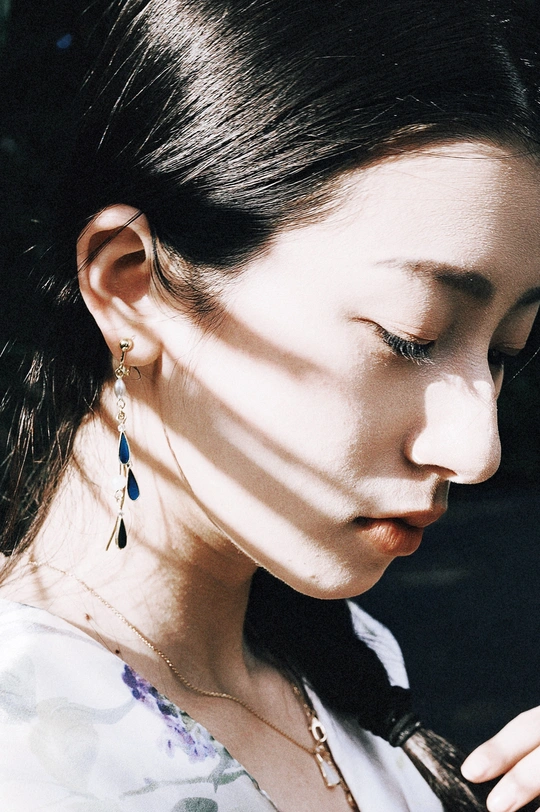 一位穿着领带和黑色耳环的年轻女子