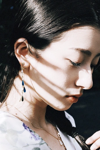 一位穿着领带和黑色耳环的年轻女子