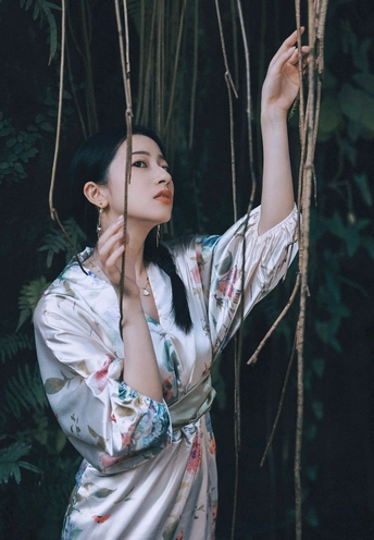 一位穿着和服的女子站在一棵棵树木组成的森林中