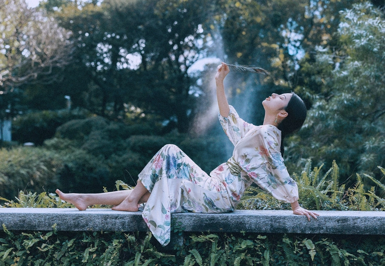 一位坐在喷泉前面的墙壁上的女人