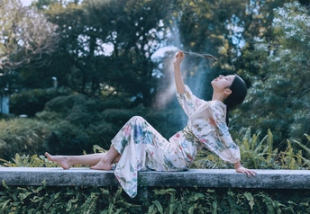 一位坐在喷泉前面的墙壁上的女人