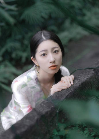 一位年轻女子在森林中为肖像画做姿势