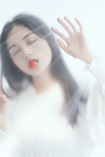 一位年轻女子举起手机贴在嘴唇上