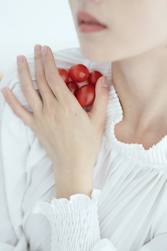 一位女子手里拿着一个红番茄