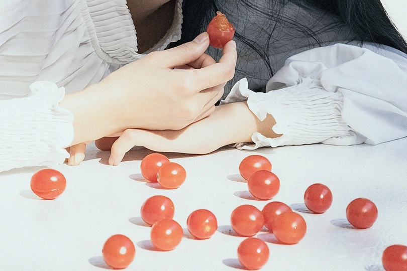 一位年轻女子拿着一束红番茄