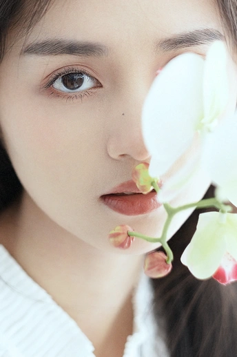 一位年轻女子脸上的白色花朵肖像