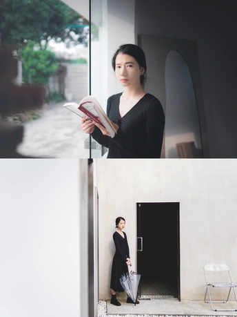 一张年轻女子拿着一本书站在敞开的门前的照片