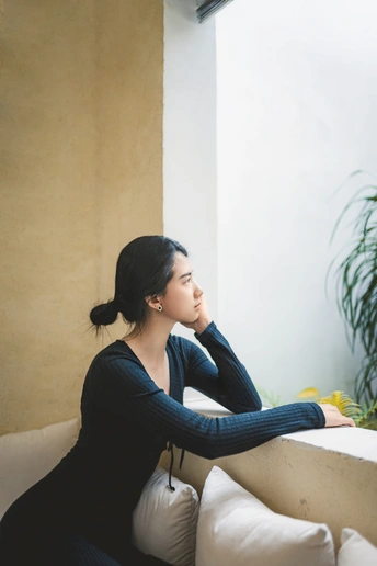 一个坐在沙发上看着窗外的年轻女子