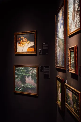 一个艺术画廊里有一面黑暗的墙 上面挂着几幅画。