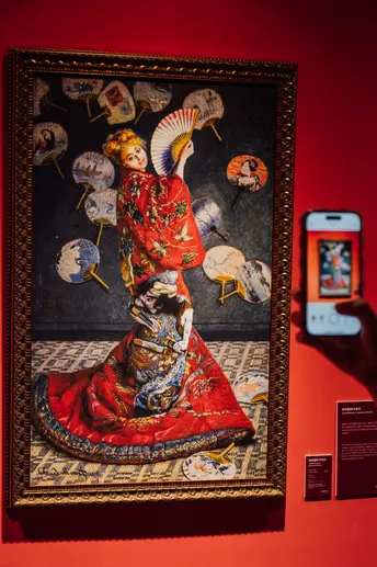 一位女士正在博物馆里拍一幅画