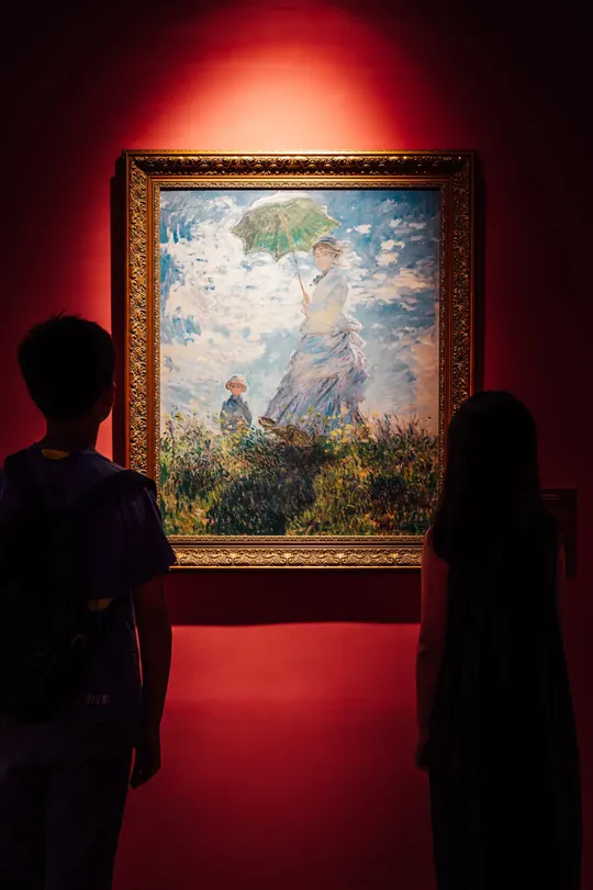 一些人站在一幅画前 画中是一位女士正在欣赏艺术。