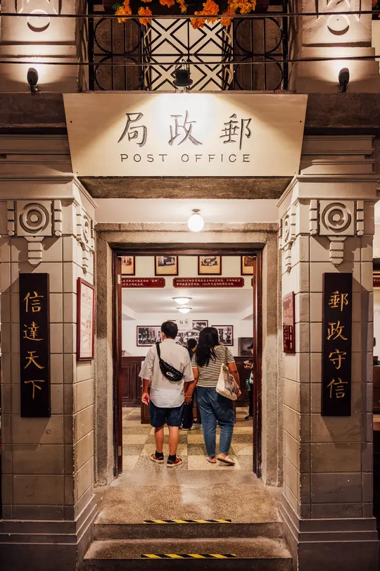 一些人站在一栋建筑的入口处夜晚