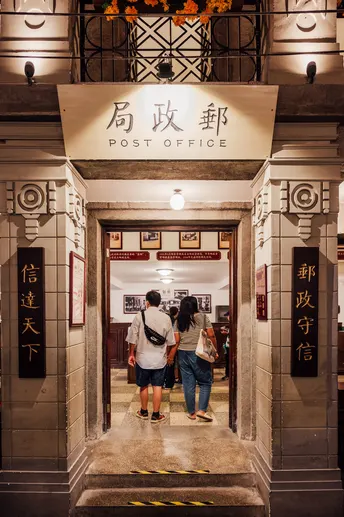 一些人站在一栋建筑的入口处夜晚