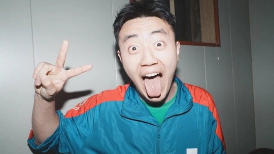 一位年轻人用手和嘴做鬼脸对着相机