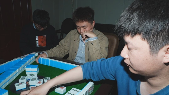 两个年轻男子在桌子旁玩一个游戏