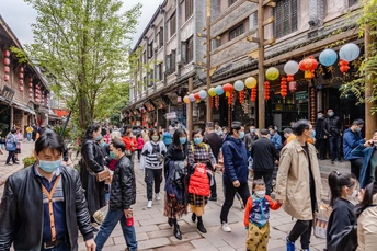 城市中一条拥挤的街道 许多人都戴着口罩。