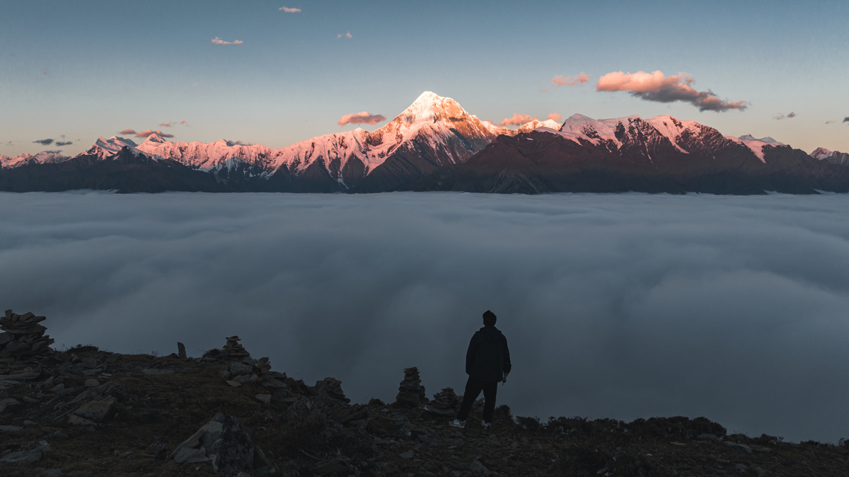 站在山顶上 俯瞰云海和雾气的一个人