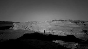 一个黑白风景画 一个人站在沙漠中