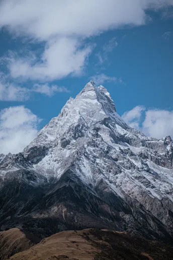 雪山上有一座高耸的山峰 与蓝天白云相映成趣。
