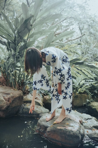 一个女人站在溪流中的岩石上